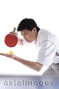 Asia Images Group - Young man playing table tennis, preparing to serve