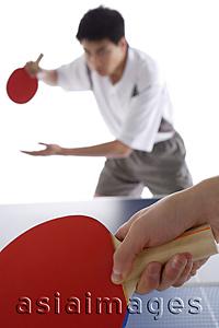 Asia Images Group - Two men playing table tennis, focus on the foreground