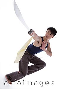 Asia Images Group - Young man practicing Kong fu with sword