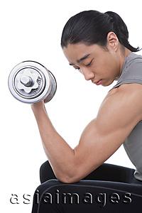 Asia Images Group - Man performing bicep curl with dumbbell