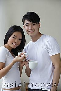 Asia Images Group - Couple holding cups, smiling at camera