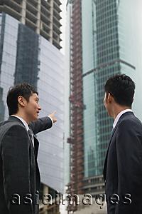 Asia Images Group - Businessmen in the city, looking at buildings in the background