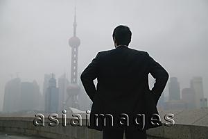 Asia Images Group - Businessman looking at Oriental Pearl TV Tower in the background