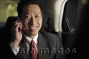 Asia Images Group - Mature man sitting in back of a car talking on the phone
