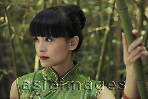 Asia Images Group - Young woman wearing a traditional Chinese dress and standing in front of bamboo trees