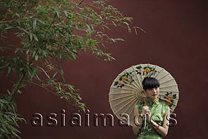 Asia Images Group - Young woman wearing a traditional Chinese dress holding an umbrella