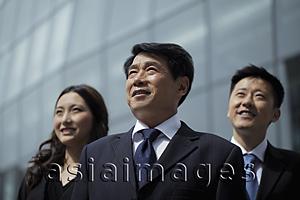 Asia Images Group - Business people looking up in front of a building