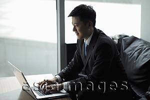 Asia Images Group - Young man working on a laptop