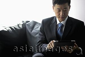 Asia Images Group - Young man in suit working on a tablet