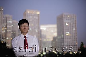 Asia Images Group - Young man standing in front of buildings in evening, China