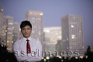 Asia Images Group - Young man standing in front of buildings in the evening, China