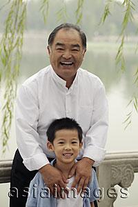 Asia Images Group - Grandfather and young boy smiling in front of a lake