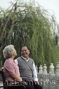 Asia Images Group - Older couple looking at each other and laughing in a park