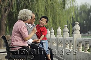 Asia Images Group - Grandparents playing with their grandson in a park