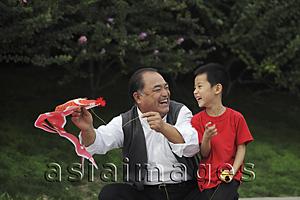 Asia Images Group - Grandfather and grandson playing with kite