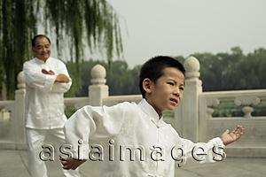 Asia Images Group - Older man watches young boy do Tai Chi, Beijing China
