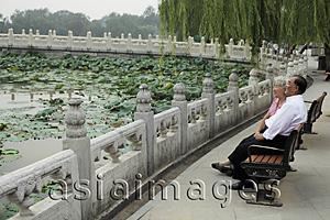 Asia Images Group - Older couple sitting on park bench looking at view