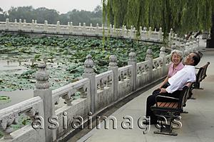 Asia Images Group - Older couple sitting on park bench laughing together
