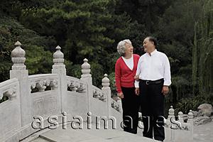 Asia Images Group - Older couple standing on bridge looking at each other