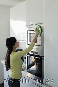 Asia Images Group - Young woman cleaning kitchen
