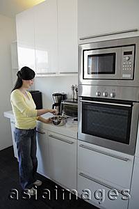 Asia Images Group - Woman cooking in kitchen