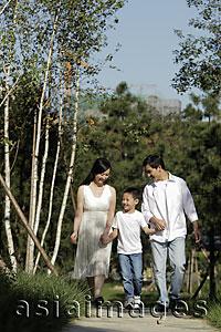 Asia Images Group - Young family walking down a path and holding hands