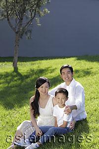 Asia Images Group - Young family sitting on grass smiling