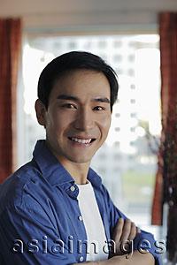 Asia Images Group - Head shot of man smiling in front of window