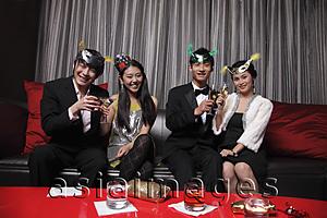 Asia Images Group - Four people celebrating at a party together