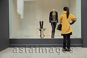 Asia Images Group - Young woman looking in shop window