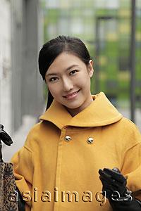 Asia Images Group - Head shot of young woman holding shopping bags and smiling