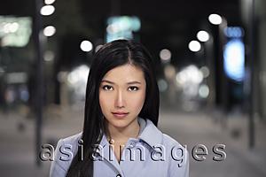 Asia Images Group - Head shot of young woman on the street at night