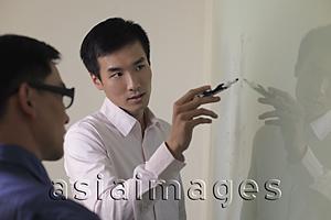 Asia Images Group - Man explaining something on white board.