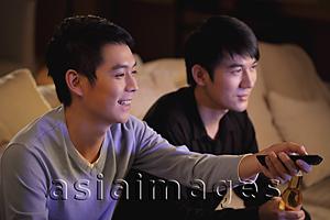 Asia Images Group - Young men watching TV together and smiling