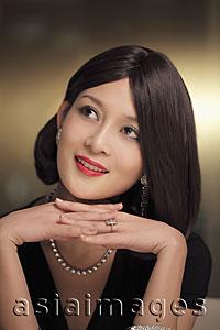 Asia Images Group - Head shot of a beautiful woman wearing diamond jewelry