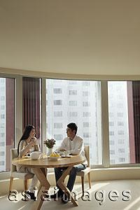 Asia Images Group - Young couple sitting at table in their condo