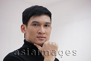Asia Images Group - Head shot of young man with hand on chin