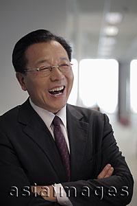 Asia Images Group - Head shot of mature man in business suit laughing