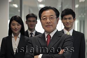Asia Images Group - Businessman standing in front of his colleagues