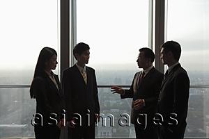 Asia Images Group - Four businesspeople standing in front of a window