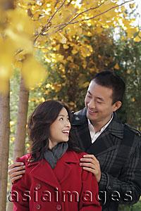 Asia Images Group - Young couple under the trees smiling at each other