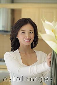 Asia Images Group - Young woman arranging flowers