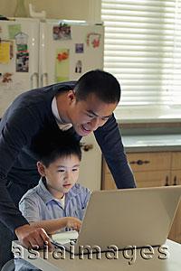 Asia Images Group - Father and son working on laptop computer together