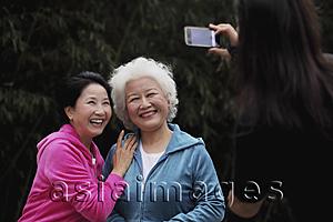 Asia Images Group - Two older women smiling while having their photo taken