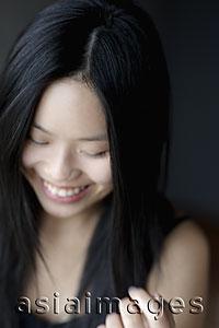Asia Images Group - Head shot of young woman smiling and looking down