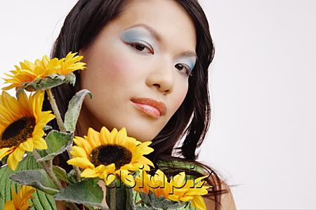 AsiaPix - Young woman, with bouquet of sunflowers, looking at camera