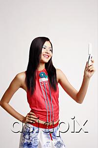 AsiaPix - Young woman looking at mobile phone, smiling