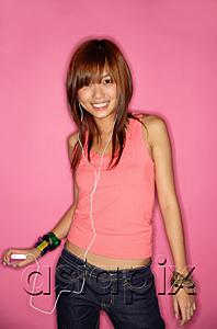 AsiaPix - Young woman standing, holding mp3 player