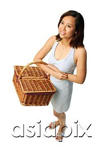 AsiaPix - Woman carrying picnic basket, looking away