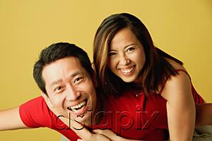 AsiaPix - Couple smiling at camera, woman hugging man from behind